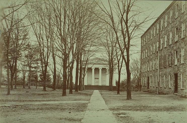 Distant view of facade of the original structure, with West College at right (photo from album, 1873)